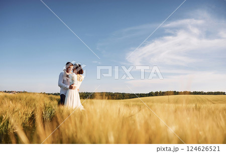 Conception of love. Couple just married. Together on the majestic agricultural field at sunny day Conception of love. Couple just married. Together on the majestic agricultural field at sunny day 124626521