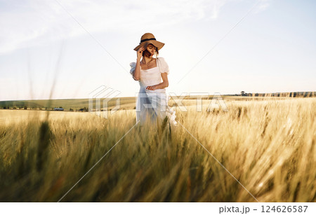 Majestic view. Beautiful young bride in white dress is on the agricultural field at sunny day Majestic view. Beautiful young bride in white dress is on the agricultural field at sunny day 124626587