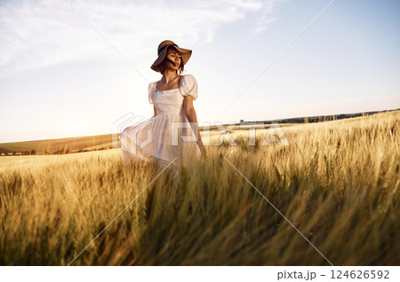 Nice landscape. Beautiful young bride in white dress is on the agricultural field at sunny day 124626592