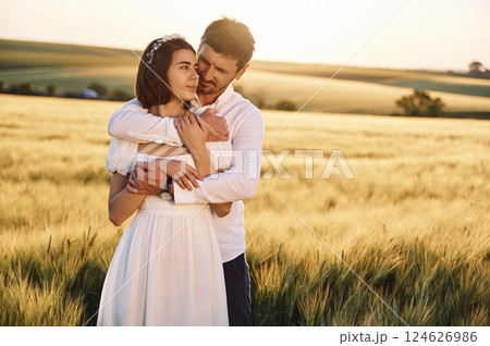 Front view. Embracing each other. Couple just married. Together on the majestic agricultural field at sunny day 124626986