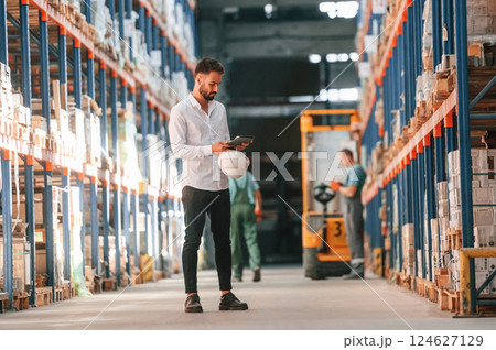 Using tablet to check the products. Storage worker is in the warehouse 124627129