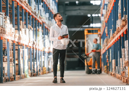 Using tablet to check the products. Storage worker is in the warehouse 124627131