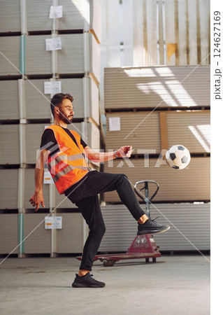 Playing soccer. Storage worker is in the warehouse with bunch of products 124627169