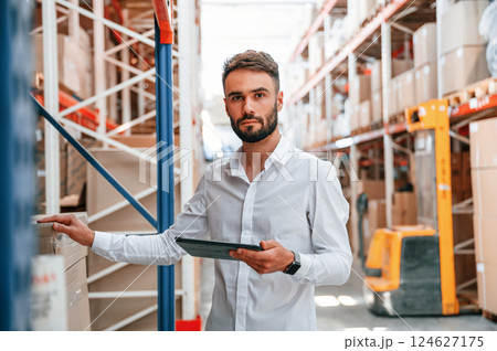 Portrait of storage worker that is in the warehouse with bunch of products 124627175