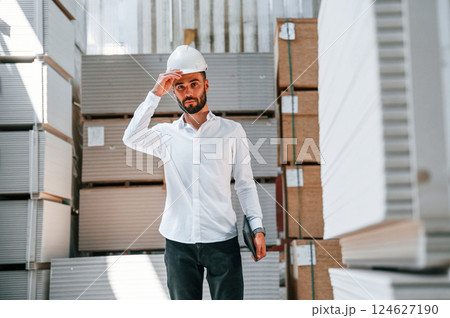 In formal clothes. Storage worker is in the warehouse with bunch of products 124627190