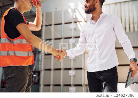 Standing together. Two storage workers is in the warehouse 124627386