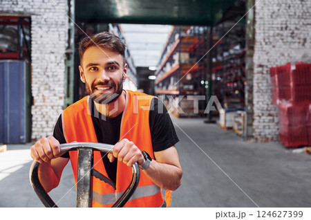 On the trolley platform. Storage worker is in the warehouse with bunch of products 124627399