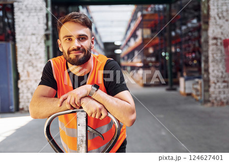 On the trolley platform. Storage worker is in the warehouse with bunch of products 124627401