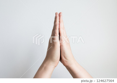Close up of caucasian adult hands in prayer gesture against white background 124627564