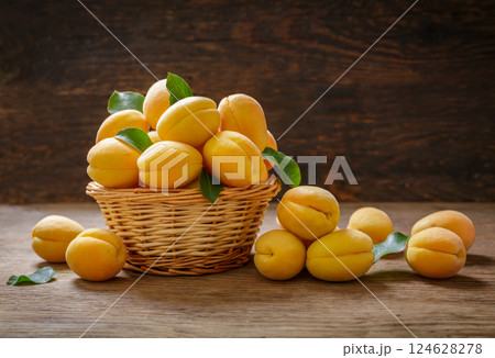 basket of fresh apricots on wooden background 124628278
