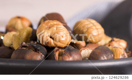 Roasted chestnuts in cast iron pan Roasted chestnuts in cast iron pan 124629286