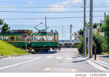 海沿いの踏切を通過する江ノ電、鎌倉、七里ヶ浜 124629998