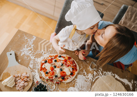 Daughter and mother making pizza together for dinner at the kitchen Daughter and mother making pizza together for dinner at the kitchen 124630166