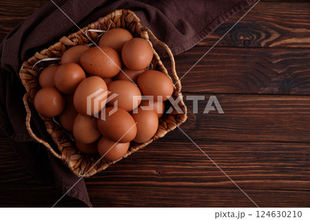 Basket of fresh farm chicken eggs on a wooden rustic background 124630210