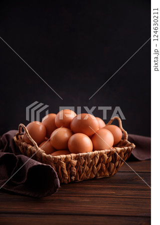 Basket of fresh farm chicken eggs on a wooden rustic background Basket of fresh farm chicken eggs on a wooden rustic background 124630211