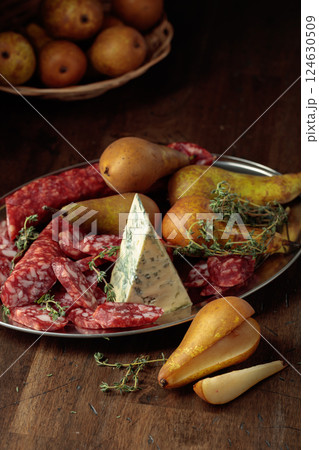 Dry-cured sausages, blue cheese, thyme and pears. Dry-cured sausages, blue cheese, thyme and pears. 124630509