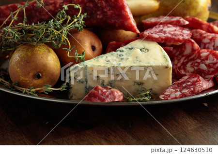 Dry-cured sausages, blue cheese, thyme and pears. Dry-cured sausages, blue cheese, thyme and pears. 124630510