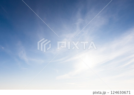 A serene image showcasing a clear blue sky adorned with soft, wispy clouds A serene image showcasing a clear blue sky adorned with soft, wispy clouds 124630671