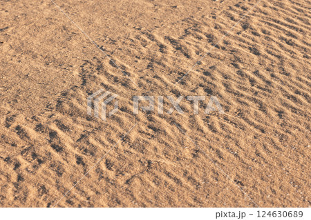 A close-up image showing intricate sand patterns formed by gentle ripples 124630689