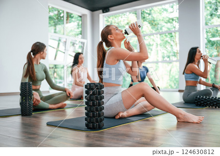 Sitting and taking a break. Group of women practicing fitness in the gym 124630812