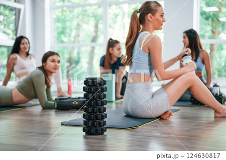 Resting on the mats. Group of women practicing fitness in the gym 124630817