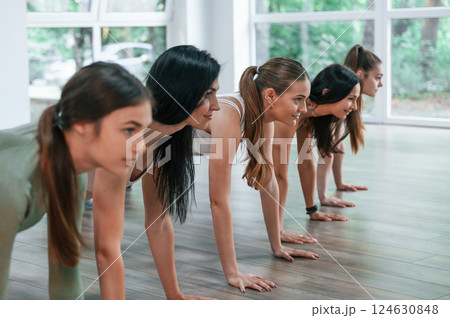 Doing plank. Group of women practicing fitness in the gym Doing plank. Group of women practicing fitness in the gym 124630848