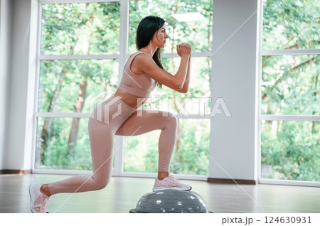 Using special platform. Woman in sportive clothes is having fitness day in the gym 124630931