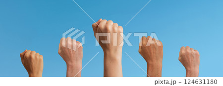 Clenched fists raised in unity, symbolizing freedom and feminist power. Women and girls in a crowd, Clenched fists raised in unity, symbolizing freedom and feminist power. Women and girls in a crowd, 124631180