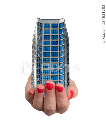 Hand holding a small model of a modern building with a glass window, home ownership and investment. 124631202