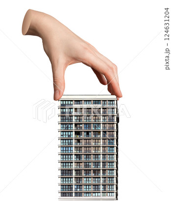 Hand holding a small model of a modern house or apartment, ownership and real estate investment. 124631204