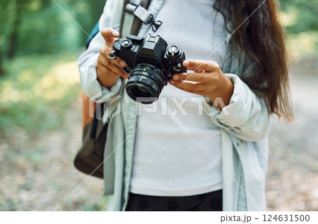 Using professional camera. Girl is in the forest at summer day time discovering new places 124631500