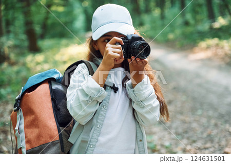 Using professional camera. Girl is in the forest at summer day time discovering new places 124631501