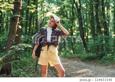 Standing and looking at nature. Girl is in the forest at summer day time discovering new places Standing and looking at nature. Girl is in the forest at summer day time discovering new places 124631546