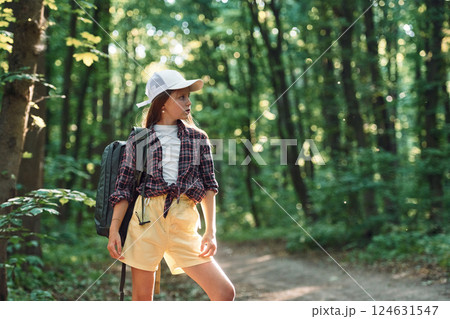 Standing and looking at nature. Girl is in the forest at summer day time discovering new places 124631547