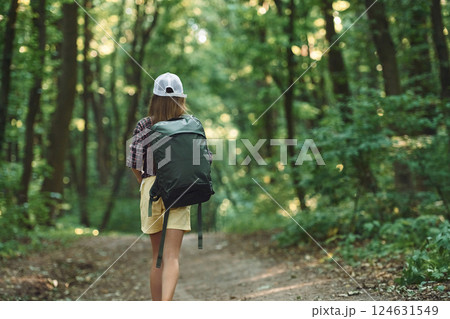 Rear view. Girl is in the forest at summer day time discovering new places Rear view. Girl is in the forest at summer day time discovering new places 124631549