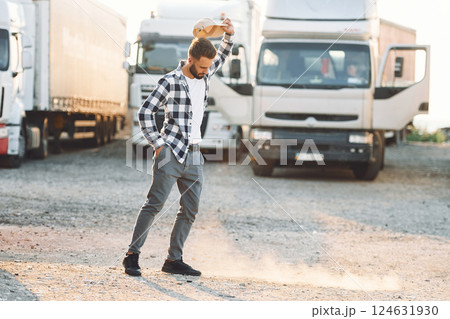 Standing and feeling bored. Young truck driver is with his vehicle at daytime 124631930