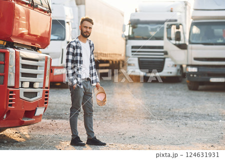 Tired, walking outside. Young truck driver is with his vehicle at daytime 124631931