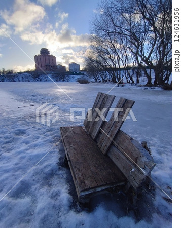 Broken Wooden Bench on Frozen Lake in Winter Sunset 124631956
