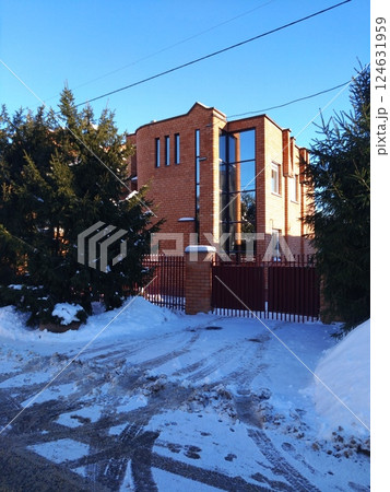 Snowy Driveway Leading to Modern Brick House 124631959