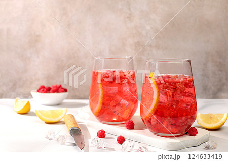 Refreshing summer homemade lemonade cocktail, mojito with raspberry, currant, mint and lemon, weight loss concept, detox water with fruit flavor on light background. healthy and natural food, 124633419