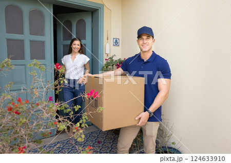 Deliveryman and client posing for camera standing on house porch Deliveryman and client posing for camera standing on house porch 124633910