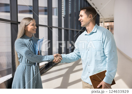Colleagues talking, greeting each other with handshake gesture Colleagues talking, greeting each other with handshake gesture 124633929