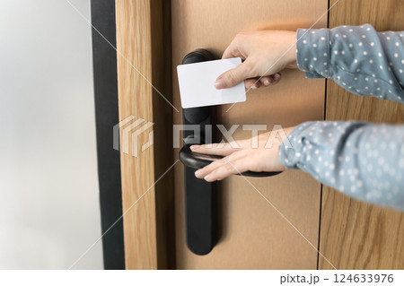 Closeup hands using keycard to access modern door with lock Closeup hands using keycard to access modern door with lock 124633976