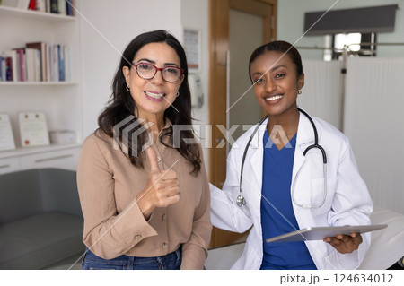 Happy satisfied mature woman recommending young African doctor 124634012