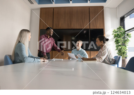 Young African professional man explains contract terms diverse clients 124634013