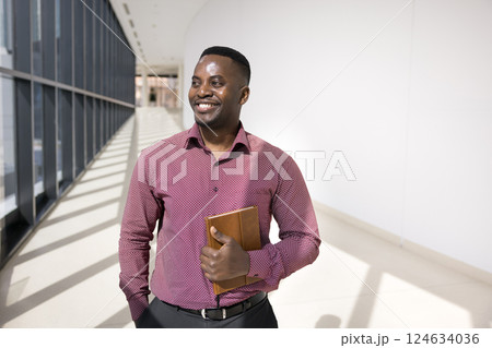 Businessman looking into distance with dreamy, contented smile 124634036