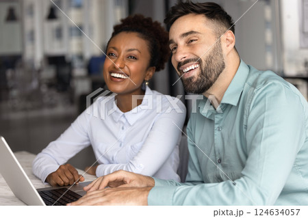 Diverse couple of cheerful young employees meeting at laptop 124634057