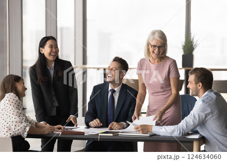 Multiethnic staff members joking, laughing during briefing or seminar event Multiethnic staff members joking, laughing during briefing or seminar event 124634060