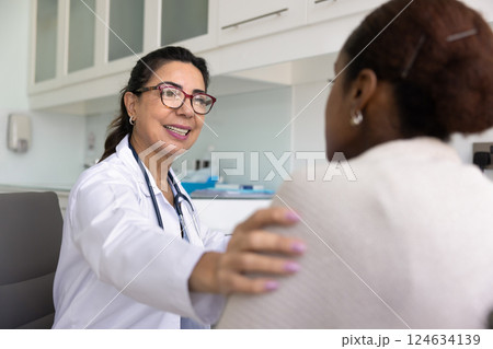 Happy positive senior doctor talking to young patient Happy positive senior doctor talking to young patient 124634139
