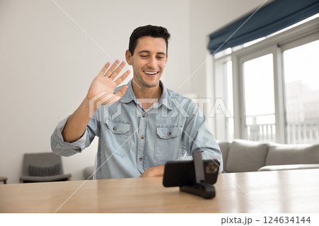 Young man participating in virtual meeting or videocall using smartphone 124634144